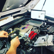 Auto mechanic checking car battery voltage